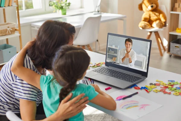 Madre e figlia comunicare online con la giovane donna medico sul computer portatile — Foto Stock