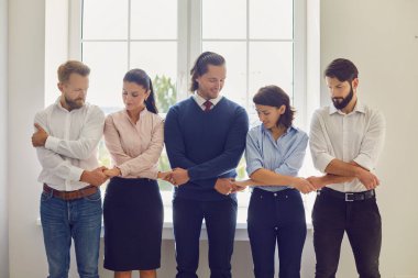 Pozitif ofis çalışanları el ele tutuşup birbirlerini destekliyorlar.