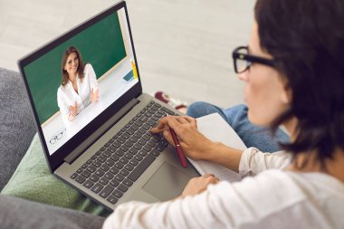 Öğrenci evde oturuyor, çevrimiçi kurslar dinliyor, video konferansı yapıyor ve dil öğreniyor. Çevrimiçi eğitim.