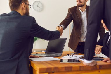 Genç iş adamları anlaşma yapıyor ve el sıkışarak işbirliğini doğruluyor