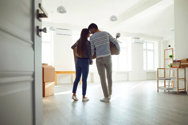 Vista posteriore in movimento. Famiglia giovane coppia con scatole per trasferirsi in una nuova stanza della casa. — Foto Stock