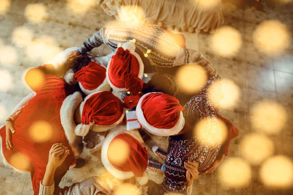 Top uitzicht op Santas hoeden met vrienden met Kerstmis. — Stockfoto