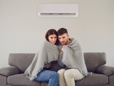 Buz gibi bir çift serin bir odada kareli kumaşla sarılıyor.