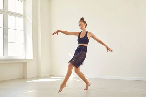 Серьезная молодая танцовщица, практикующая в одиночку в новой студии современного танца — стоковое фото