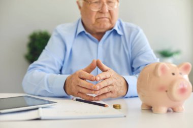 Masasında not defteri, tableti ve kişisel finans işleriyle uğraşan kıdemli bir adam var.