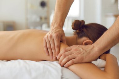 Kadın masaj masasında uzanıyor sağlık kliniğinde ya da lüks kaplıcalarda narin vücut masajı yapıyor.