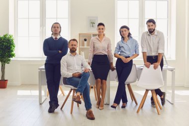 Modern ofiste buluştuktan sonra mutlu iş adamları ve iş kadınlarının toplu portresi