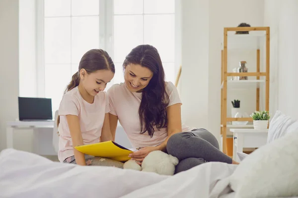 Mutter und Tochter lesen zu Hause im Bett Buch. Eltern und Kind genießen Märchengeschichte im Schlafzimmer — Stockfoto