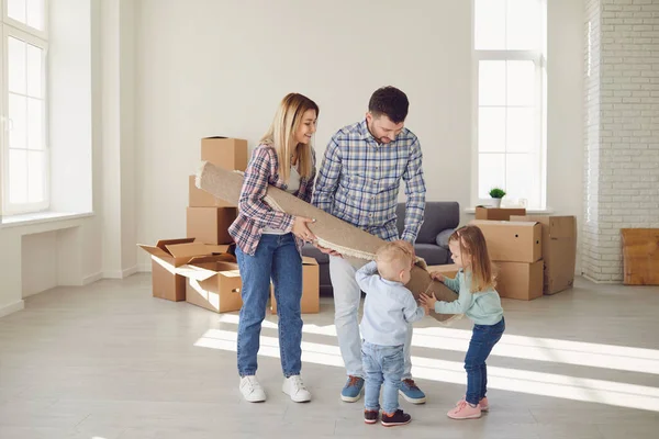 Ευτυχισμένη οικογένεια με χαλί στο πάτωμα σε ένα νέο διαμέρισμα. — Φωτογραφία Αρχείου