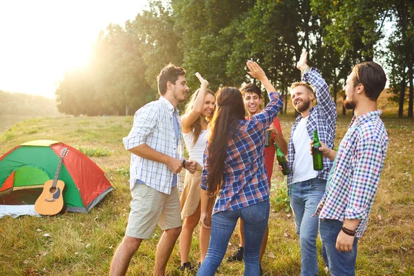 Молодые люди весело улыбаются, стоя на траве на пикнике — стоковое фото