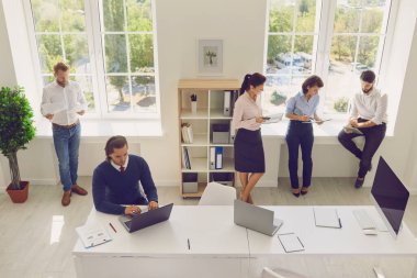 Modern ofiste yeni başlatılan projeyle çalışan genç konsantre yaratıcı iş arkadaşları.