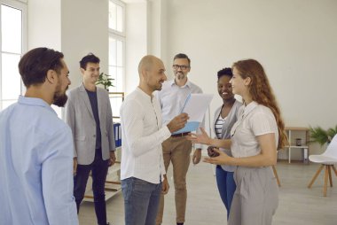 Ofiste çalışma gününün başlangıcı. Ofiste çalışan olumlu bir erkek yönetici astlarına görevler verir. Lider mutlu ofis çalışanı listesi veriyor. İş konsepti.
