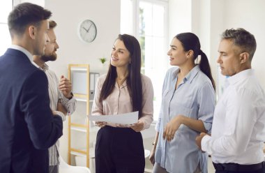 Modern ofisteki çeşitli çalışanlar projeyi tartışıyor, iş adamları ve iş kadınları konuşuyor, iş arkadaşları iş yerinde iş konuşuyorlar, iletişim fikirleri konuşuyorlar.