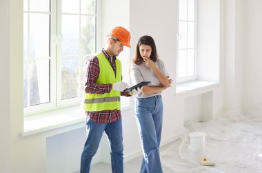 Mimar ve müvekkil, bir ev yenileme planı ve planını gözden geçirerek bir tartışmaya giriştiler. Brifingde başarılı bir proje için inşaat ve işbirliği planlaması üzerinde duruldu.