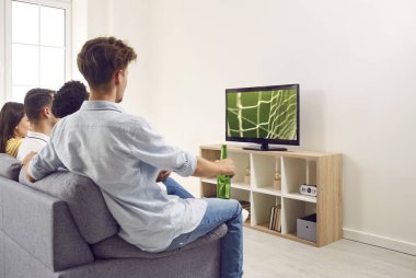 Çok uluslu arkadaşlar ve taraftarlar, büyük bir odadaki bir kanepede oturup birlikte TV 'de bir futbol maçı izlemek için bir araya geldiler. Rekabetçi spor konsepti, futbol taraftarları.