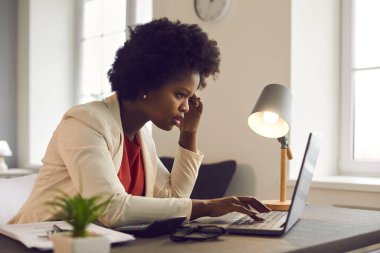 Çevrimiçi problem, finansal hata, sorun yaratma. Düşünceli genç afro-amerikalı afro-amerikan iş kadını laptopa bakıyor haberleri, haberleri ya da e-postayı okurken kötü hissediyor.