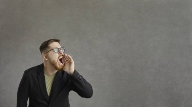 Sakın kaçırmayın. Bağıran, reklam bilgilerini duyuran, gri arka planda duran aktif bir adam. Duygusal adam çılgın indirimler duyurdu. Reklam afişi. Metin için yer.