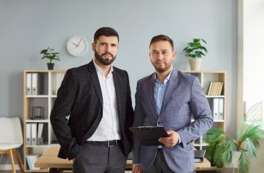 Ofisteki grup veya ekipteki ciddi iş adamlarının portresi, profesyonel bir ortamda işbirliği ve ortaklığa odaklanmış, takım çalışması, iş bağlılığı ve adanmışlık duygusu ile.