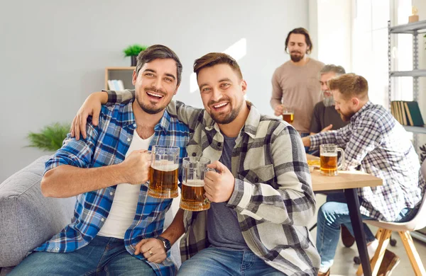 Genç erkek arkadaşlar evde eğleniyor ve bira içiyorlar. Ekose gömlekli iki mutlu adamın portresi evdeki kanepede oturmuş, sarılıyor, bira bardakları tutuyor, kameraya bakıyor ve gülümsüyor.