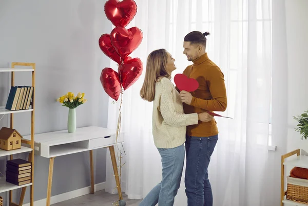 Mutlu, genç, evli bir çift Sevgililer Günü 'nü evde geçirip birbirlerine sevgililer günü kartları ve hediyeler vererek ve birlikte iyi vakit geçirerek. Sevgililer Günü konsepti