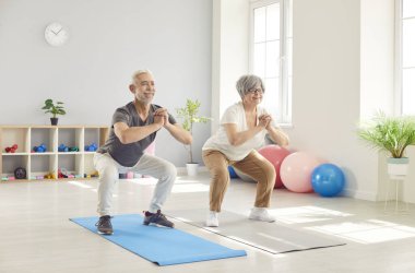 Aktif, mutlu, yaşlı, çömelmiş sabah egzersizi, spor dersinde yoga yapan, spor yapan, kulüp stüdyosunda spor yapan, vücut yağı yakma sporcusu motivasyonu, yaşlı rehabilitasyonu.
