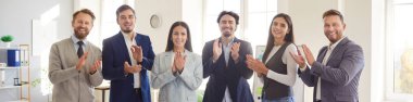 Group portrait of happy business people team applauding and celebrating success in an office. Emphasizing teamwork, organization, and happiness in a professional corporate setting.