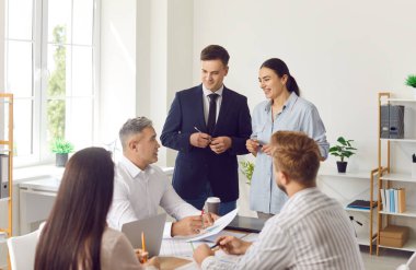 Toplantı sırasında finansal belgelerle çalışan bir grup iş adamı. Şirket çalışanları ofiste beyin fırtınası yaparak harika kararlar veriyorlar. İş arkadaşları iş arkadaşlarını dinlerler..