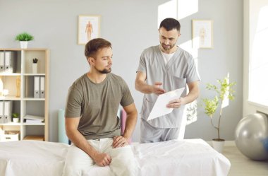 Doctor or nurse provides consultation and advice to a patient during a rehabilitation session in hospital. Medical care, support and therapy, during the rehabilitation process in a healthcare office.