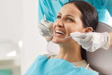Patient undergoes dental checkup in clinic with doctor dentist using instrument, focusing on oral care and dentistry medicine in a professional environment with precision and attention.