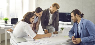 Employees reads, analyzes and edits paper documents while working in modern office center. Business team is discussing marketing strategy or planning companys economic growth. Brainstorming concept.