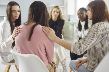 Group of women friends supporting woman who is in depression, discussing problems and life situations and trying to solve them together, having therapy session, helping to cope with difficulties