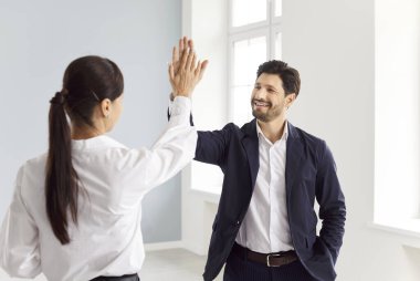 Realtor and client, man giving high five woman after successful meeting, deal, contract, happy young couple rejoice, businessman and businesswoman celebrating closing deal, project finish supporting