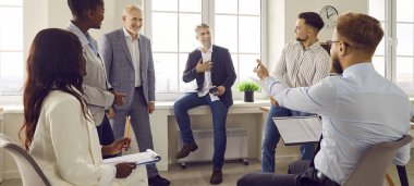 Group of business people chatting on a meeting. Company employees talking in the office and making great decisions with brainstorming. Cowokers listen to their colleague at the working place. Banner.