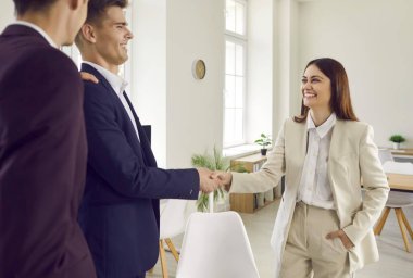 Modern ofiste duran ve iş arkadaşlarıyla tokalaşan zeki üç iş adamından oluşan bir grup. İş arkadaşları anlaşmaya varıyor veya yeni çalışanları selamlıyor.