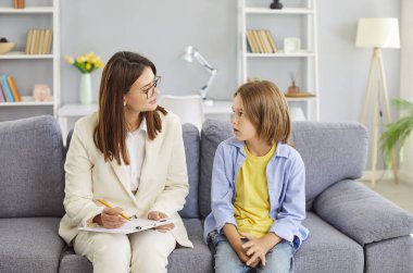 Doctor psychologist holds a therapy session with a schoolboy, providing support for mental health. The psychotherapy session offers guidance and care, helping the boy through consultation.