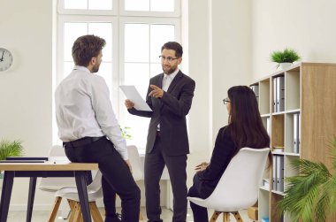 Kendine güvenen genç iş adamlarından oluşan bir grup toplantıda bir iş projesini tartışıyor. İş arkadaşları ve şirket çalışanları iş arkadaşlarını dinliyor ve ofiste konuşuyorlar. Takım çalışması konsepti.