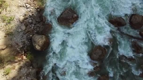 Vista de cima sobre o fluxo de água, no rio há grandes pedras — Vídeo de Stock