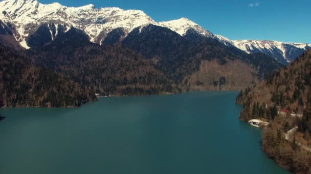 Aero tiro de nieve cubierto de grandes montañas y lago azul en el día de verano — Vídeos de Stock