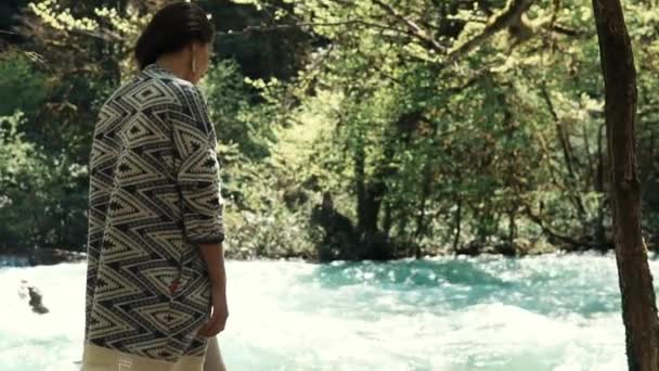 Woman stands near the stream of a river, lady rejoices in a beautiful landscape — Stock Video