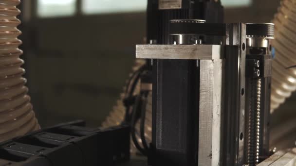 Gros plan des détails mobiles de la machine CNC. Les pièces sont soulevées et tournantes pendant l'exécution d'un programme de production 