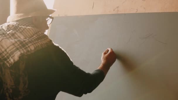 Творческий пенсионер наносит карандашные метки, контуры гор на холст — стоковое видео