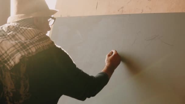 Creative pensioner applies pencil marks, outline of the mountains to the canvas — Stock Video