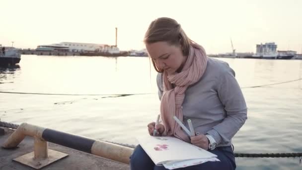 Krásné umělec sedí u řeky. — Stock video