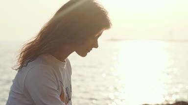 Sevimli kız sahilde doğanın keyfini.