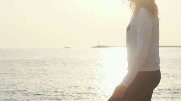 Adolescente bonito correndo em torno da praia, ela está girando apreciando a vista do mar — Vídeo de Stock