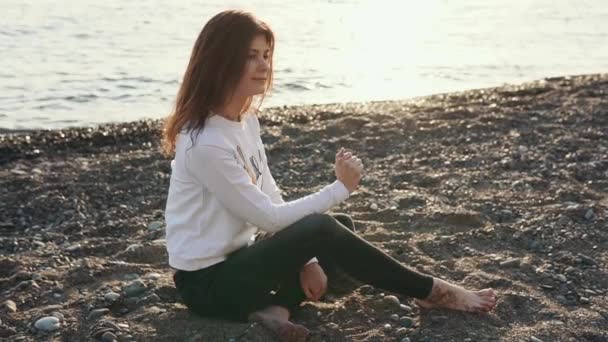 젊은 여자는 해변에 조용히 앉아. — 비디오