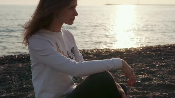 Menina encantadora senta-se na praia sozinho . — Vídeo de Stock