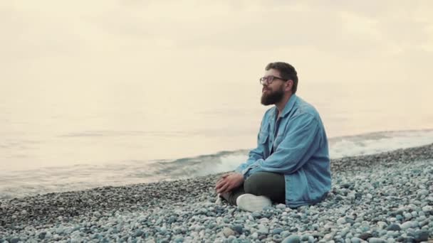 Handsome Bearded Man Wearing Glasses Jeans Jacket Sitting Beach Smiling — Stock Video