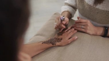 Yetenekli kadın genç kadının elinde kına tarafından Arap desen çizim
