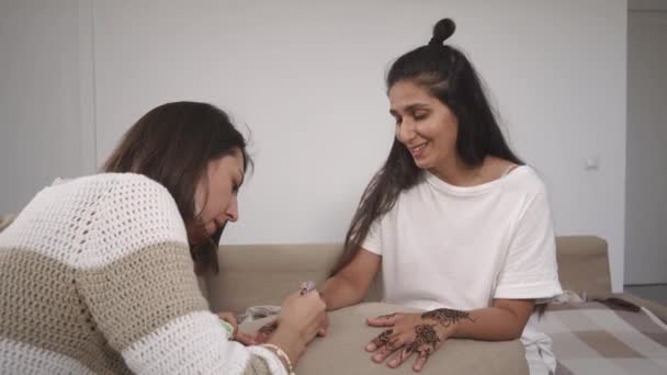 Dois amigos estão envolvidos em desenhar henna nas mãos para obter um talismã forte — Vídeo de Stock